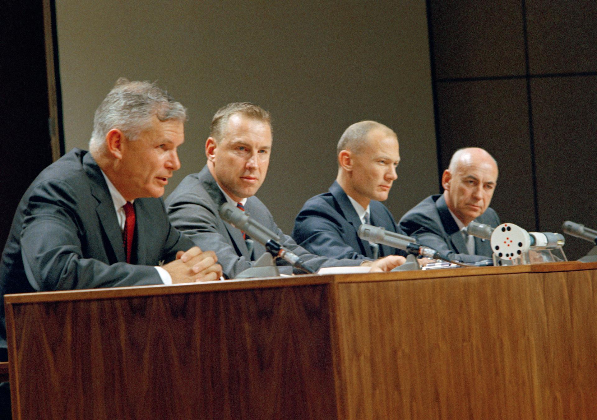 Seamans, Jim Lovell, Buz Aldrin and Robert Gilruth sit at a table for a press conference.