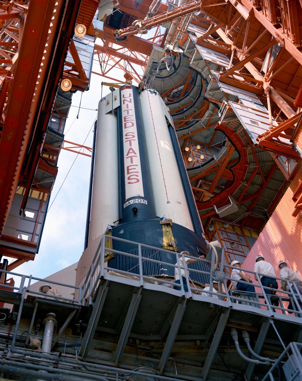 S68-29781 (22 April 1968) --- Low angle view at the Kennedy Space Center's Pad 34 showing the erection of the first stage of the Saturn 205 launch vehicle. The two-stage Saturn IB will be the launch vehicle for the first unmanned Apollo space mission, Apollo 7 (Spacecraft 101/Saturn 205).