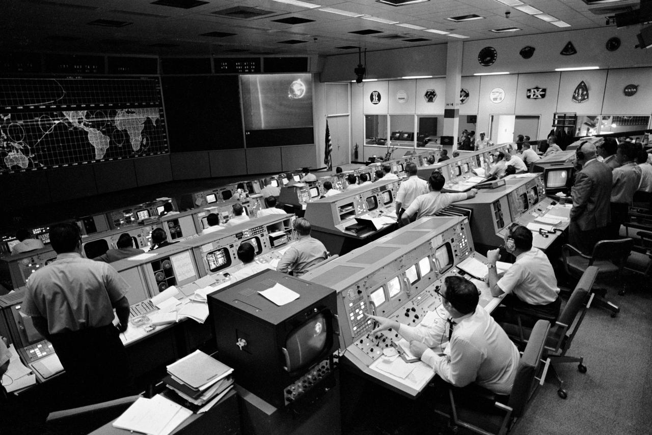 S69-34039 (18 May 1969) --- Overall view of activity in the Mission Operations Control Room in the Mission Control Center, Building 30, on the first day of the Apollo 10 lunar orbit mission. This picture was taken following CSM/LM-S-IVB separation, and prior to LM extraction from the S-IVB. The telecast from the Apollo 10's color TV camera shows the LM still attached to the S-IVB. The CSM is making the docking approach to the LM/S-IVB.