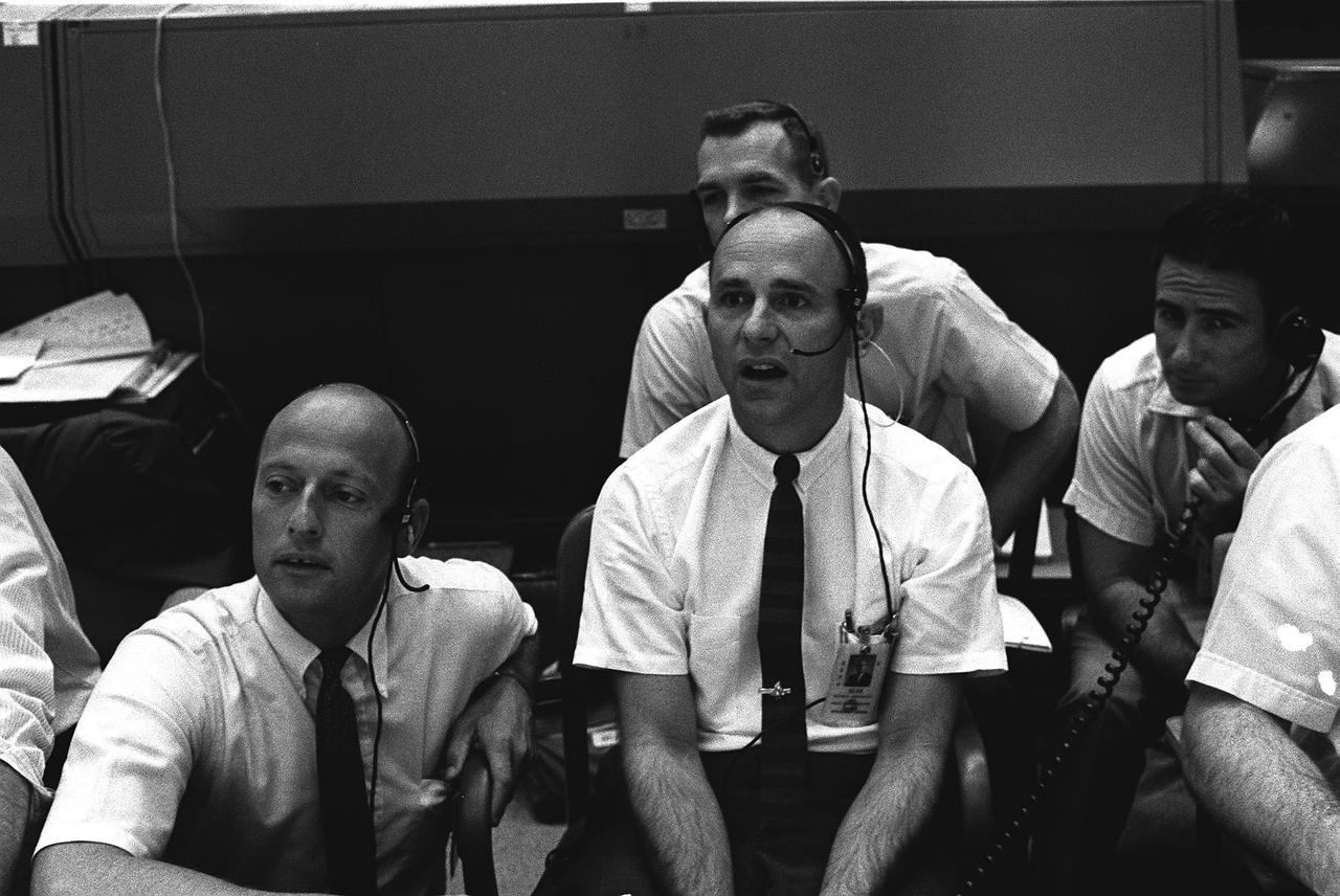 S69-39600 (20 July 1969) --- Four members of the prime and backup crews for Apollo 12 monitor activity of the first moon landing mission from consoles in the Mission Control Center in Houston. Left to right are astronauts Charles Conrad Jr., Alan L. Bean, David R. Scott and James B. Irwin. Astronauts Armstrong and Aldrin had already landed on the moon when the photo was taken.