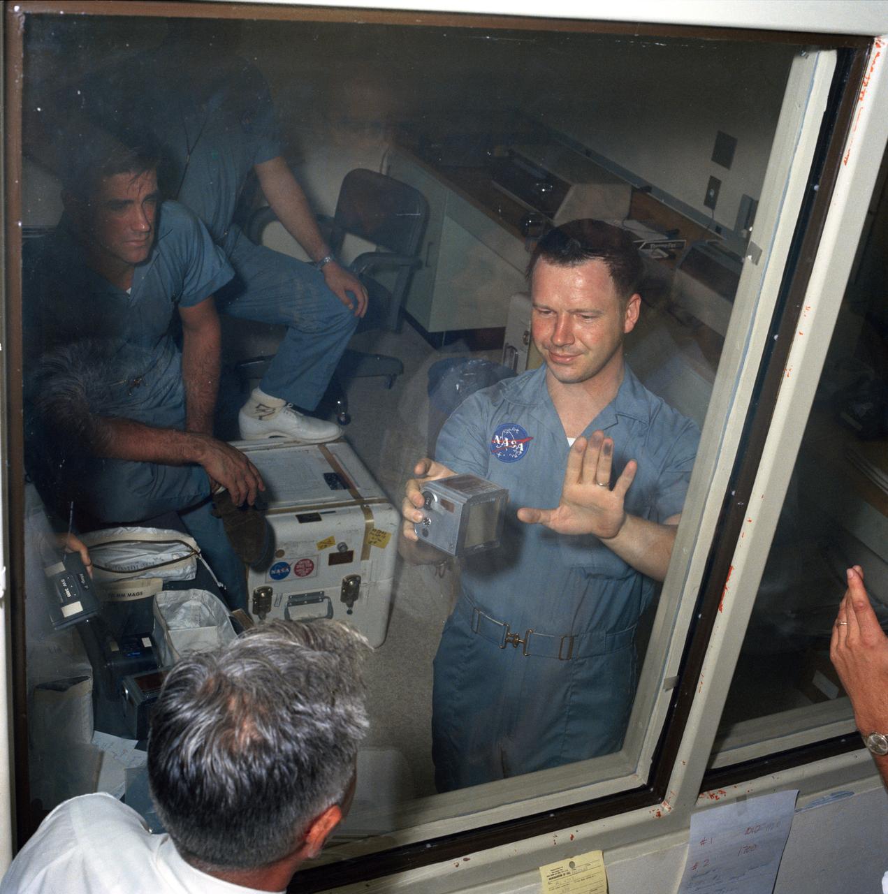 The first direct exposure to Lunar material for Crew Reception Personnel probably happened late Friday, 07/25/1969. Terry Slezak (displaying Moon dust on his left hand fingers), MSC photographic technician, was removing film magazines from the first of two (2) containers when the incident occurred. As he removed the plastic seal from Magazine "S", one of the 70mm magazines taken during Apollo XI  Extravehicular Activity (EVA), it was apparent that the exterior of the cassette displayed traces of a black powdery substance. Apollo XI Commander Neil Armstrong reported during the mission that he had retrieved a 70mm cassette which had dropped to the Lunar surface. Seen in the backgound is John H. Boynton.  ( S69-40054 )  MSC, Houston, TX