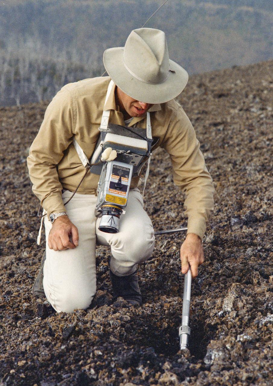 S70-20272 (December 1969) --- Astronaut James A. Lovell Jr., commander of the upcoming Apollo 13 lunar landing mission, uses a scoop from the Apollo Lunar Hand Tools (ALHT) during a simulated lunar surface traverse at the Kapoho, Hawaii training site. While at the Hawaii training sites, Lovell and Haise are participating in thorough rehearsals of their extravehicular activity (EVA). Photo credit: NASA