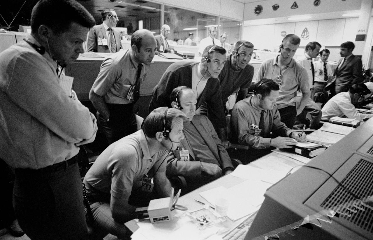 S70-34986 (14 April 1970) --- A group of six astronauts and two flight controllers monitor the console activity in the Mission Operations Control Room (MOCR) of the Mission Control Center (MCC) during the problem-plagued Apollo 13 lunar landing mission.  Seated, left to right, are MOCR Guidance Officer Raymond F. Teague; astronaut Edgar D. Mitchell, Apollo 14 prime crew lunar module pilot; and astronaut Alan B. Shepard Jr., Apollo 14 prime crew commander.  Standing, left to right, are scientist-astronaut Anthony W. England; astronaut Joe H. Engle, Apollo 14 backup crew lunar module pilot; astronaut Eugene A. Cernan, Apollo 14 backup crew commander; astronaut Ronald E. Evans, Apollo 14 backup crew command module pilot; and M.P. Frank, a flight controller.  When this picture was made, the Apollo 13 moon landing had already been canceled, and the Apollo 13 crew men were in trans-Earth trajectory attempting to bring their damaged spacecraft back home.