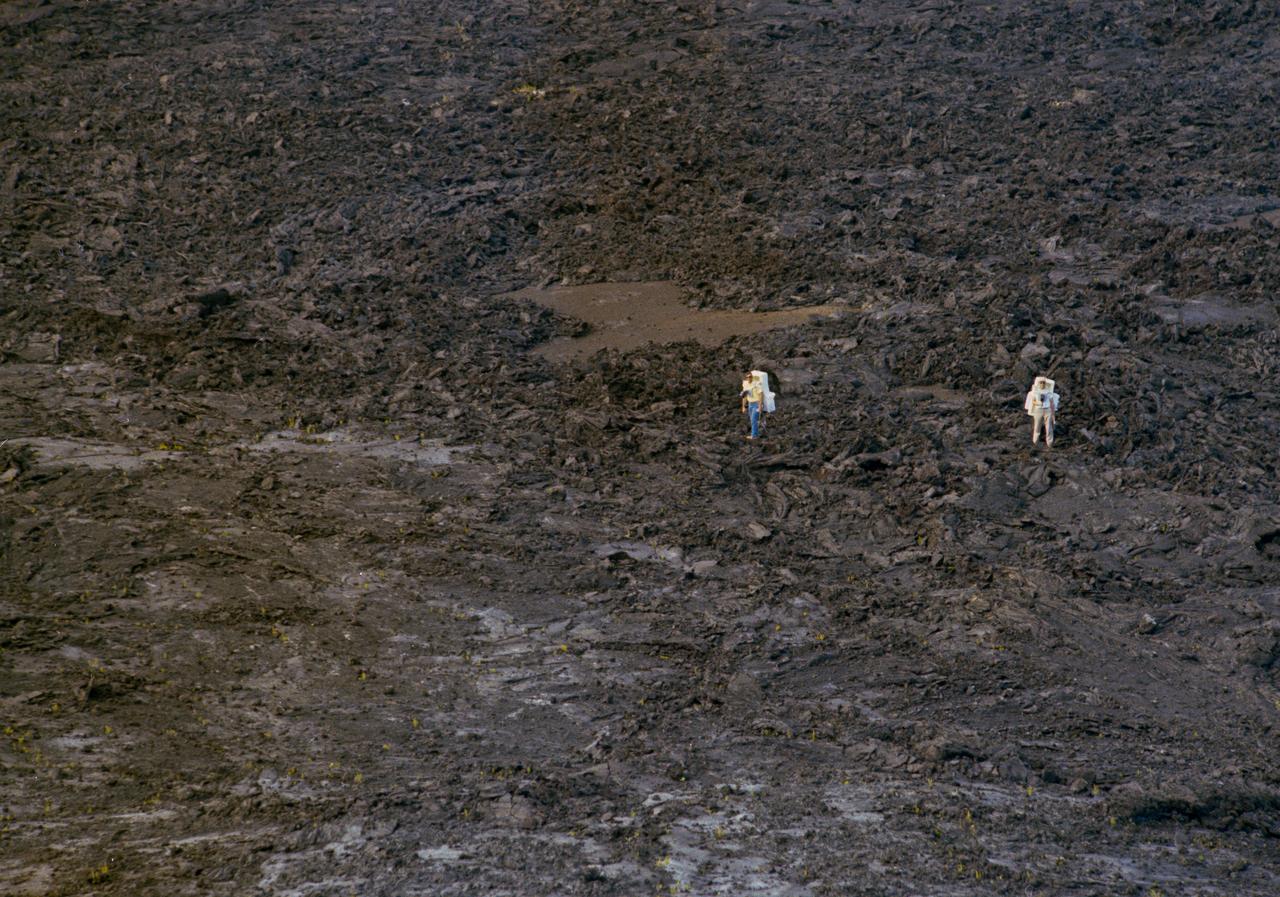 S70-56407 (December 1970) --- Astronauts Richard F. Gordon Jr., left, and Harrison H. Schmitt ? backup crew members for the Apollo 15 mission -- get ?feet-on? experience with an a'a' lava flow during geology training in Hawaii.  A?a? is the most common appearance type of lava flow that cools down, to form fragmented, often spiny or rough surfaces. Photo credit: NASA