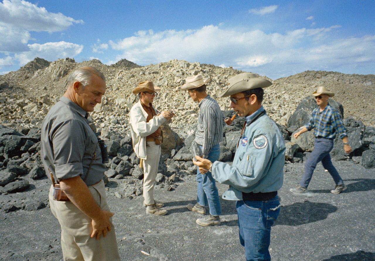S71-36874 (10 June 1971) --- University of Texas geologist/professor William R. Muelhberger (left) talks with astronaut John W. Young, Apollo 16 commander, during an Apollo 16 geology field trip to Mono Crater, Calif. Astronaut Charles Duke, lunar module pilot, is seen at frame center, talking to geologist  David Wones (second left). Astronaut Anthony England, Apollo 16 spacecraft communicator (CAPCOM), is at right. Photo credit: NASA