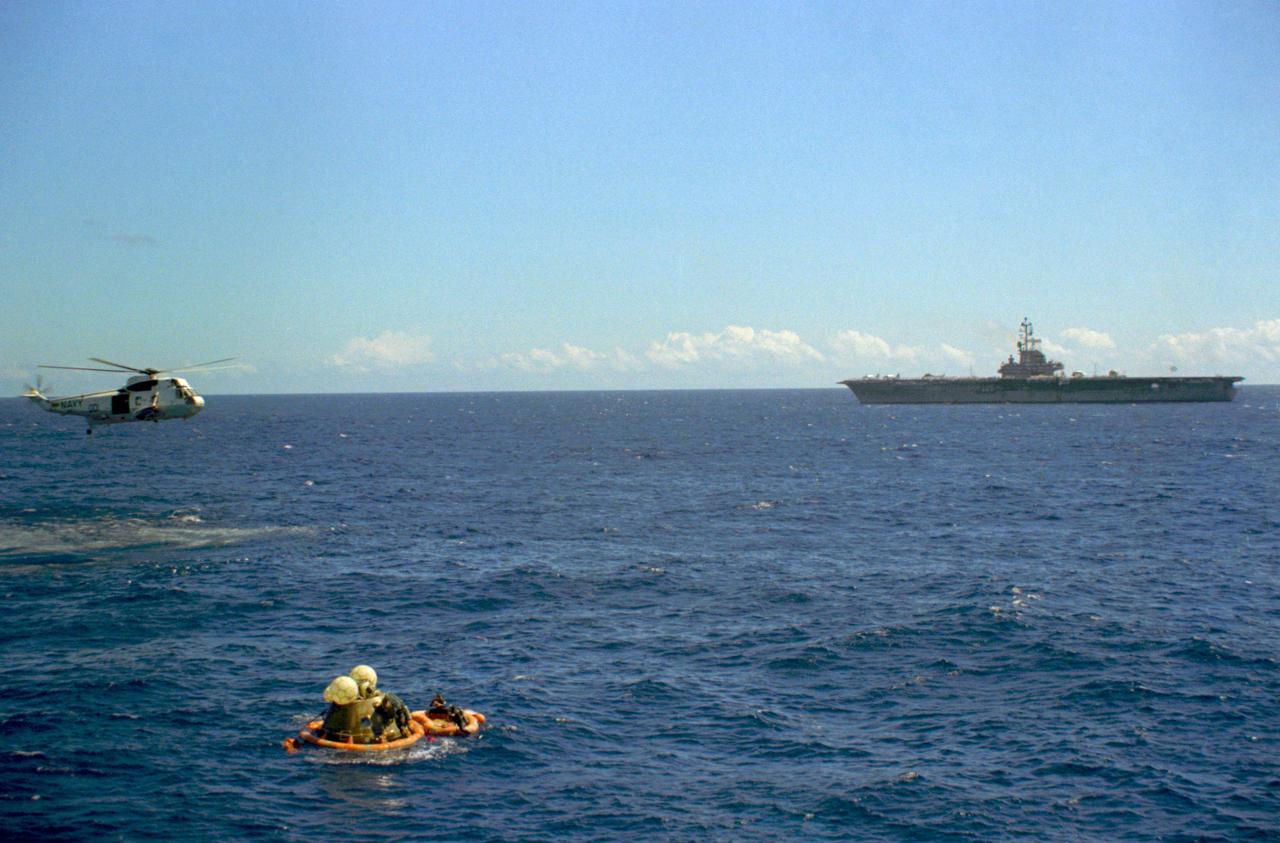 S72-36602 (27 April 1972) --- The Apollo 16 Command Module bobbles photographed in the waters of the central Pacific Ocean during recovery operations. The prime recovery ship, USS Ticonderoga, is in the background. A recovery helicopter hovers overhead. The Apollo 16 crew, astronauts John W. Young, Thomas K. Mattingly II, and Charles M. Duke Jr., were picked up by helicopter and flown to the deck of the ship. The splashdown occurred at 290:37:06 ground elapsed time, 1:45:06 p.m. (CST), Thursday, April 27, 1972, at coordinates of 00:45.2 degrees south latitude and 156:11.4 degrees west longitude, a point approximately 215 miles southeast of Christmas Island. A team of Earth Landing System swimmers assisted with the recovery operations.