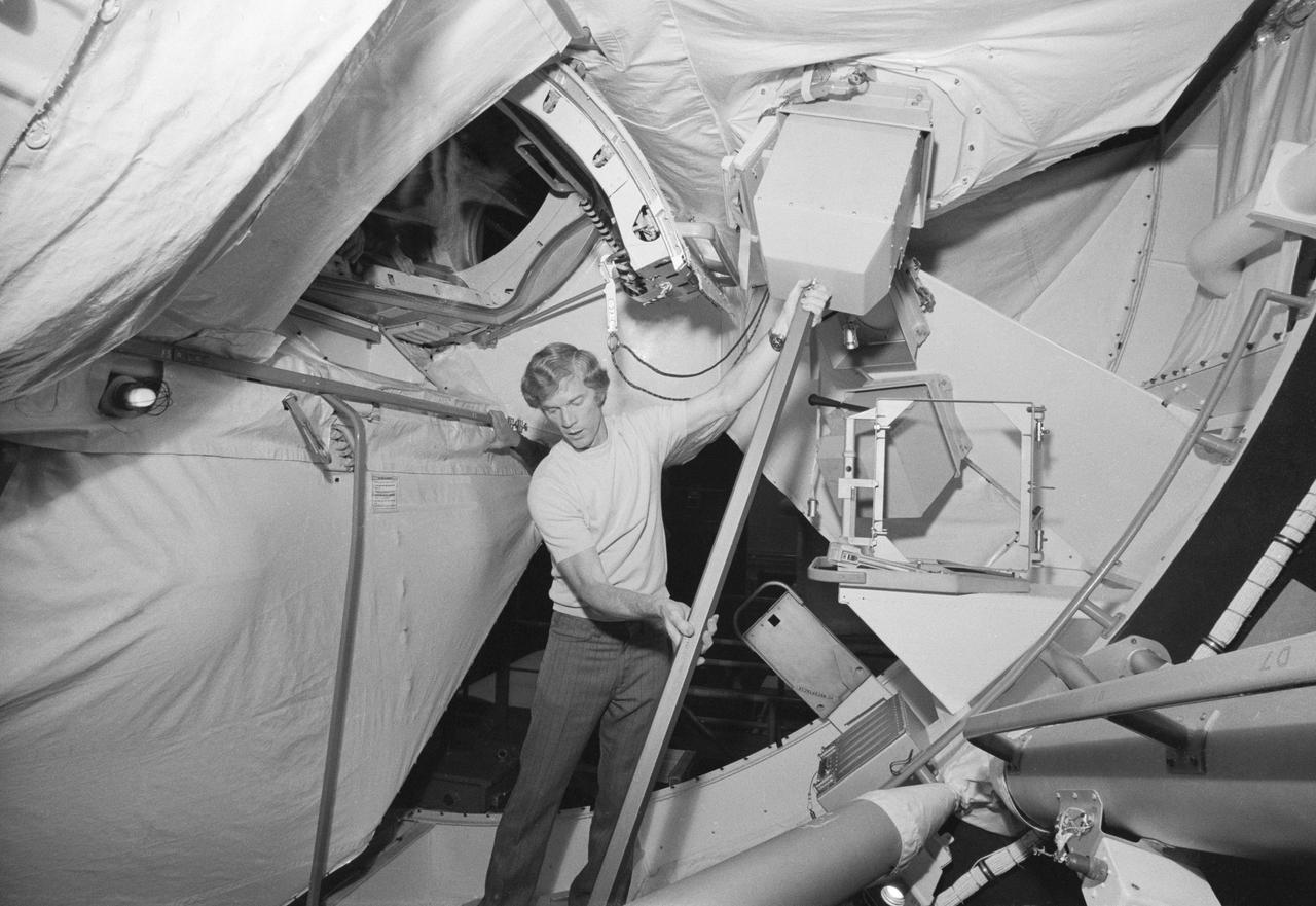 S73-25884 (1973) --- Astronaut Russell Schweickart in Orbital Workshop Simulator (OWS) working out procedure to be used for repair of damaged thermal protection cover on Skylab 2 spacecraft. Photo credit: NASA