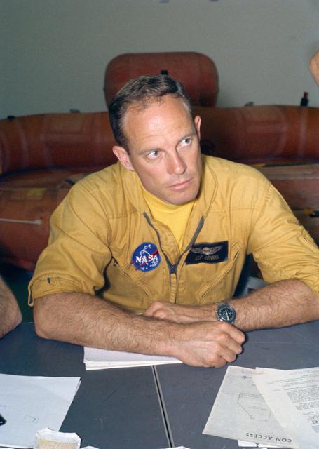 NASA image: Astronaut Jack Lousma at table with crew and flight surgeon before training
