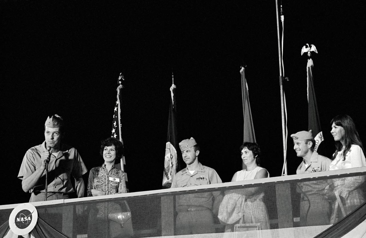 S73-28818 (24 June 1973) --- Scientist-astronaut Joseph P. Kerwin, science pilot for the Skylab 2 mission, speaks to a crowd at Ellington Air Force Base during welcome home ceremonies for the crew. Astronaut Paul J. Weitz, pilot, is at center; and astronaut Charles Conrad Jr., crew commander, is at right. The wives, standing by their husbands, are (left to right) Shirley Kerwin, Suzanne Weitz and Jane Conrad. Photo credit: NASA