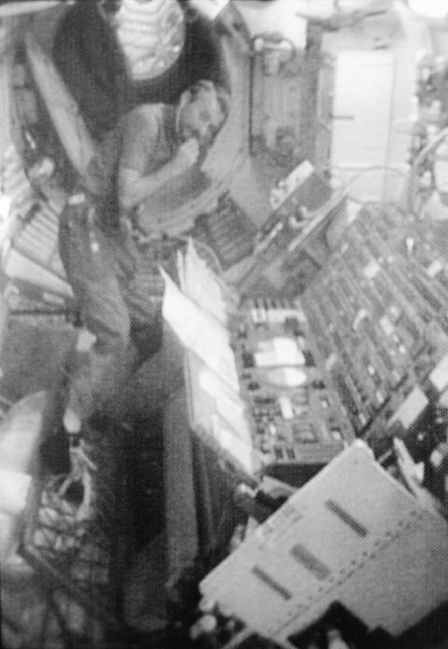 S73-31973 (August 1973) --- Scientist-astronaut Owen K. Garriott, Skylab 3 science pilot, looks at a map of Earth at the food table in the ward room of the Orbital Workshop (OWS). In this photographic reproduction taken from a television transmission made by a color TV camera aboard the Skylab space station cluster in Earth orbit. Photo credit: NASA