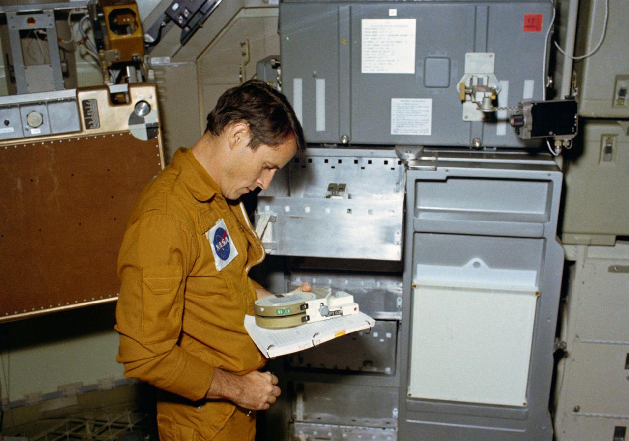 S73-32848 (10 Sept. 1973) --- Scientist-astronaut Edward G. Gibson, science pilot for the third manned Skylab mission (Skylab 4), reads the markings on a magazine of 400 feet of film for the 16mm Data Acquisition Camera (DAC), during a training exercise in the Orbital Workshop (OWS) trainer at Johnson Space Center. Photo credit: NASA