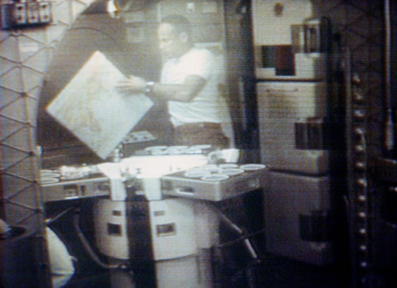 S73-34193 (1 Aug. 1973) --- Astronaut Jack R. Lousma, Skylab 3 pilot, looks at a map of Earth at the food table in the ward room of the Orbital Workshop (OWS). In this photographic reproduction taken from a television transmission made by a color TV camera aboard the Skylab space station cluster in Earth orbit. Photo credit: NASA