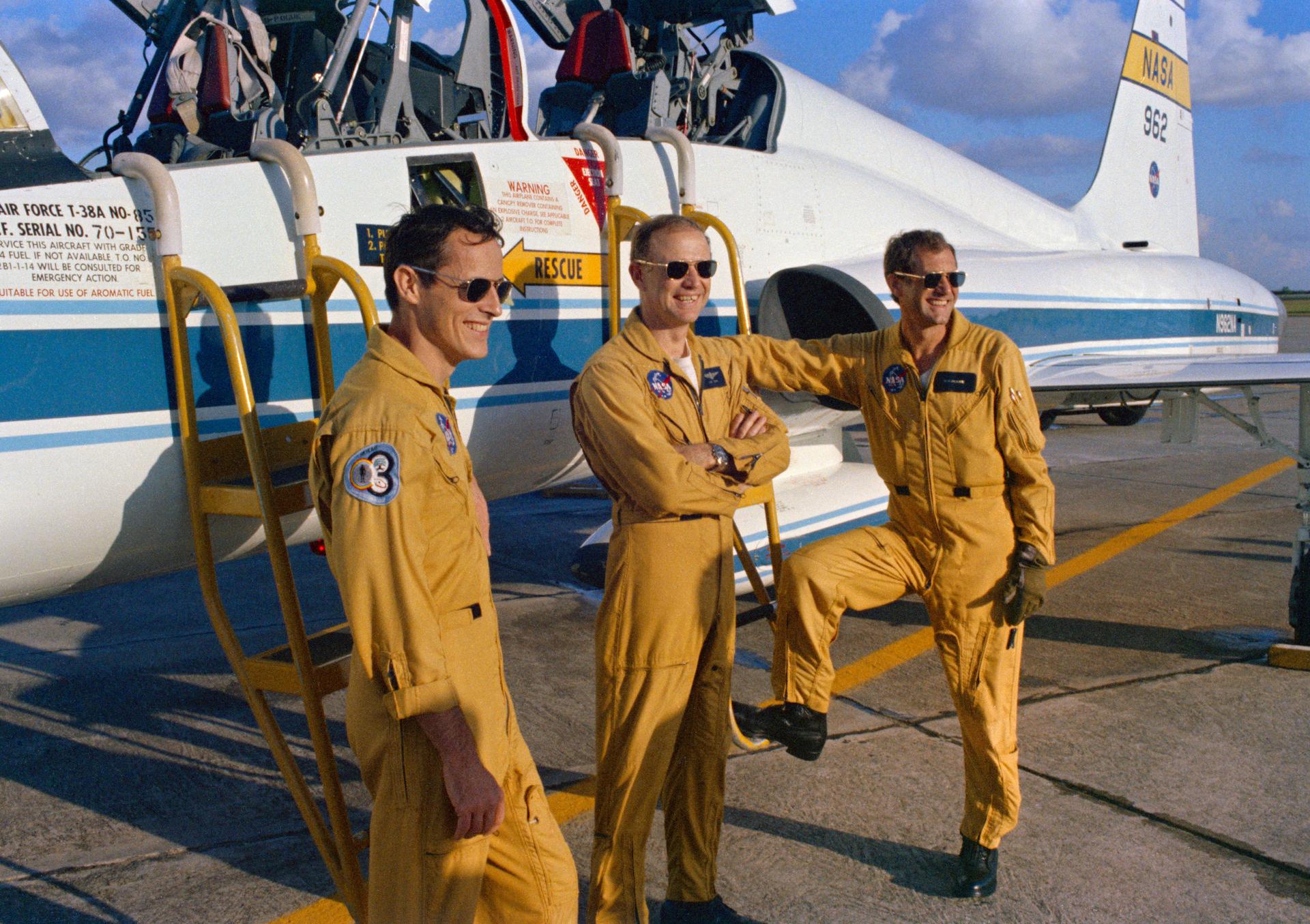 The crew of Skylab 4—Ed Gibson, Gerry Carr, and Bill Pogue—stand next to a T-38A aircraft.