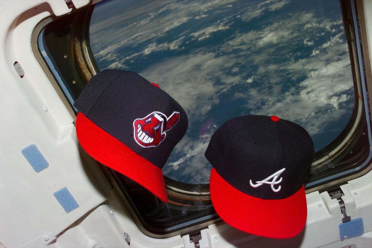 STS073-E-5135 (26 Oct. 1995) --- Baseball caps from the two 1995 World Series representative franchises float near the cabin windows of the Earth-orbiting space shuttle Columbia, with the Earth in the background. The American League champion Cleveland Indians and their National League counterpart Atlanta Braves were engaged in a scheduled best-of-seven World Series throughout the first portion of the scheduled 16-day mission in space. Off-duty crewmembers came out of a  rest period to set up the scene in tribute to the October classic. The crew will continue working in shifts around the clock on a diverse assortment of United States Microgravity Laboratory (USML-2) experiments located in the science module.  Fields of study include fluid physics, materials science, biotechnology, combustion science and commercial space processing technologies. The frame was exposed  with an Electronic Still Camera (ESC).