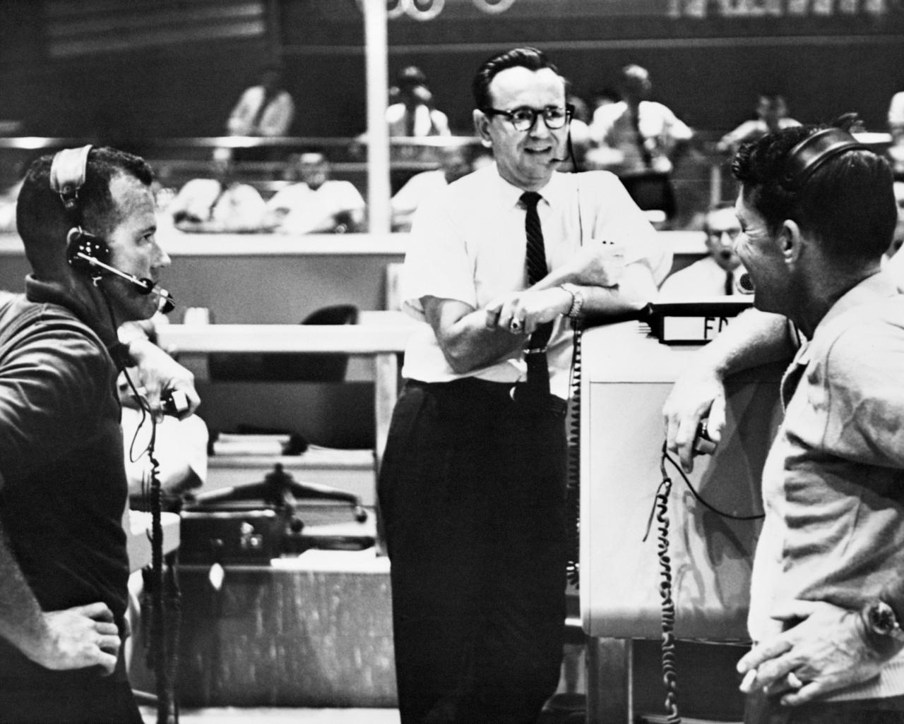 S74-33006 (19 Sept. 1962) --- Flight director Christopher C. Kraft Jr. (center), Chief of the Flight Operations Division at the Manned Spacecraft Center, Houston, discusses the Mercury-Atlas 8 (MA-8) flight plan with astronauts L. Gordon Cooper Jr. (left) and Walter M. Schirra Jr., on Sept. 19, 1962. They are standing in the Mercury Control Center at Cape Canaveral, Florida. Photo credit: NASA