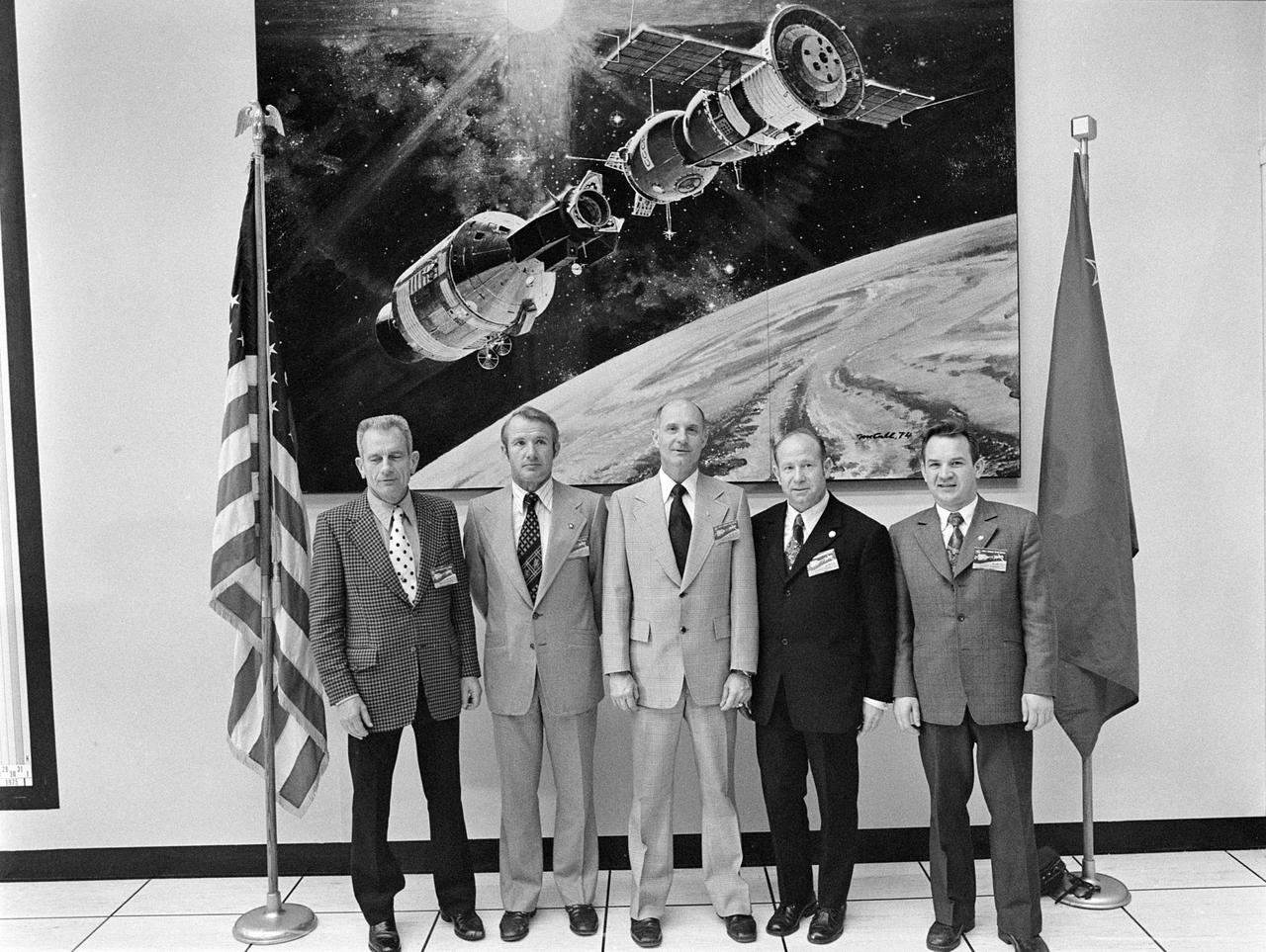 S75-24030 (8-10 Feb. 1975) --- The five prime crew members of the Apollo-Soyuz Test Project (ASTP) mission pose for a group photograph while at NASA's Kennedy Space Center (KSC) for a three-day inspection tour. They are, left to right, astronaut Donald K. (Deke) Slayton, docking module pilot of the American crew; astronaut Vance D. Brand, command module pilot of the American crew; astronaut Thomas P. Stafford, commander of the American crew; cosmonaut Aleksey A. Leonov, commander of the Soviet crew; and cosmonaut Valeriy N. Kubasov, engineer of the Soviet crew. They were at KSC to look over launch facilities and flight hardware. They are standing in front of artist Robert McCall?s painting of an ASTP docking in Earth orbit.