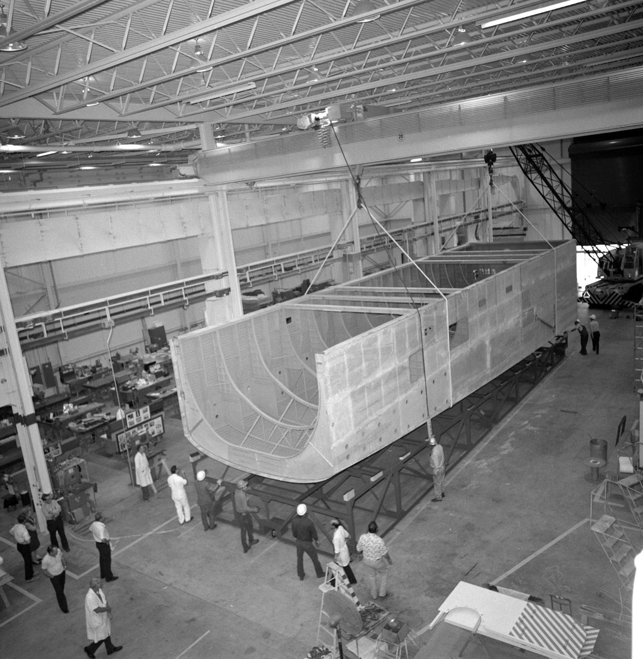 Eleven (11) wide-angle views and medium shots showing progess on construction of Shuttle Orbiter Mid-Body Mockup in Bldg. 9. Workers seen in views.     JSC, Houston, TX
