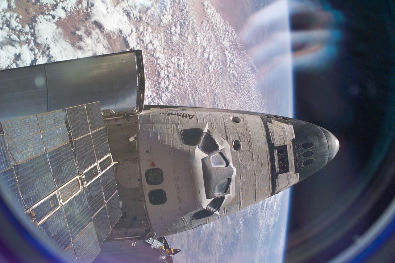 S76-E-5156 (24 March 1996) --- The forward cargo bay and the entire top exterior of the crew cabin of the Space Shuttle Atlantis can be seen in this image, recorded with a 35mm Electronic Still Camera (ESC), positioned in one of the windows aboard Russia's Mir Space Station.