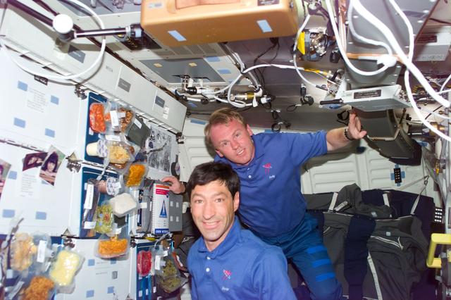 NASA image: Runco and Thomas show off trays of food on the middeck