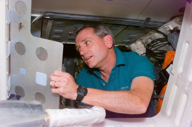 NASA image: Astronaut Akers cleans-up on the middeck