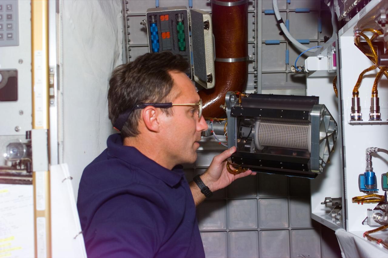 STS79-E-5041 (18 September 1996) --- Astronaut Carl E. Walz, mission specialist, checks on Mechanics of Granular Materials (MGM) experiment in Spacehab, onboard the Space Shuttle Atlantis, Flight Day 3.