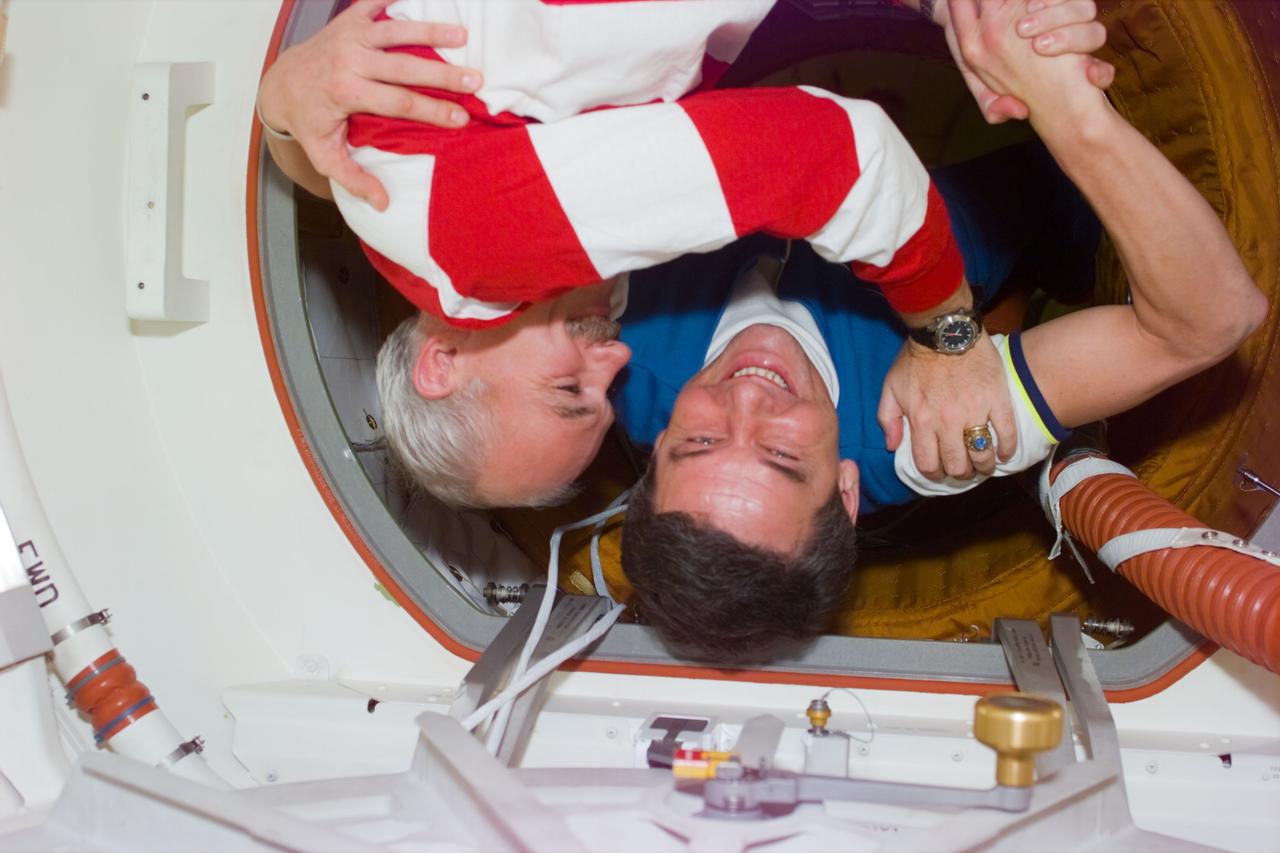 STS79-E-5090 (19 September 1996) --- Cosmonaut Valeri G. Korzun, Mir-22 commander, greets his American counterpart - astronaut William F. Readdy in the tunnel connecting the Space Shuttle Atlantis to Russia's Mir Space Station, during Flight Day 4.  This mission marks the fourth such reunion involving astronauts and cosmonauts during the Shuttle era and the fifth overall, going back to the historic Apollo-Soyuz Test Project (ASTP) in 1975.