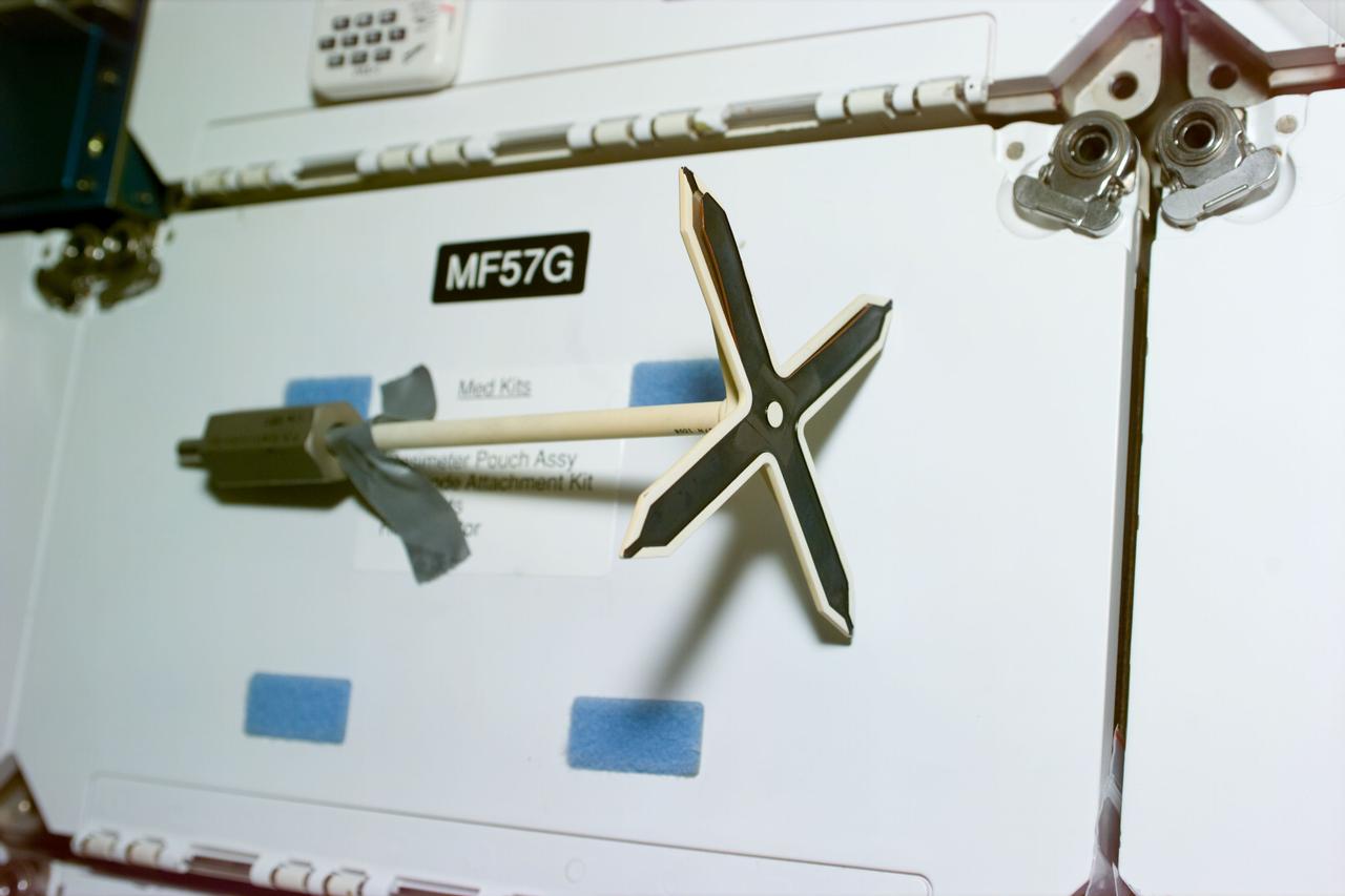 STS79-E-5104 (20 September 1996) --- The STS-79 crew members removed the docking target from the Docking Module (DM) and attached it to a locker door to photograph it and examine a slight peel on the surface, during Flight Day 5.