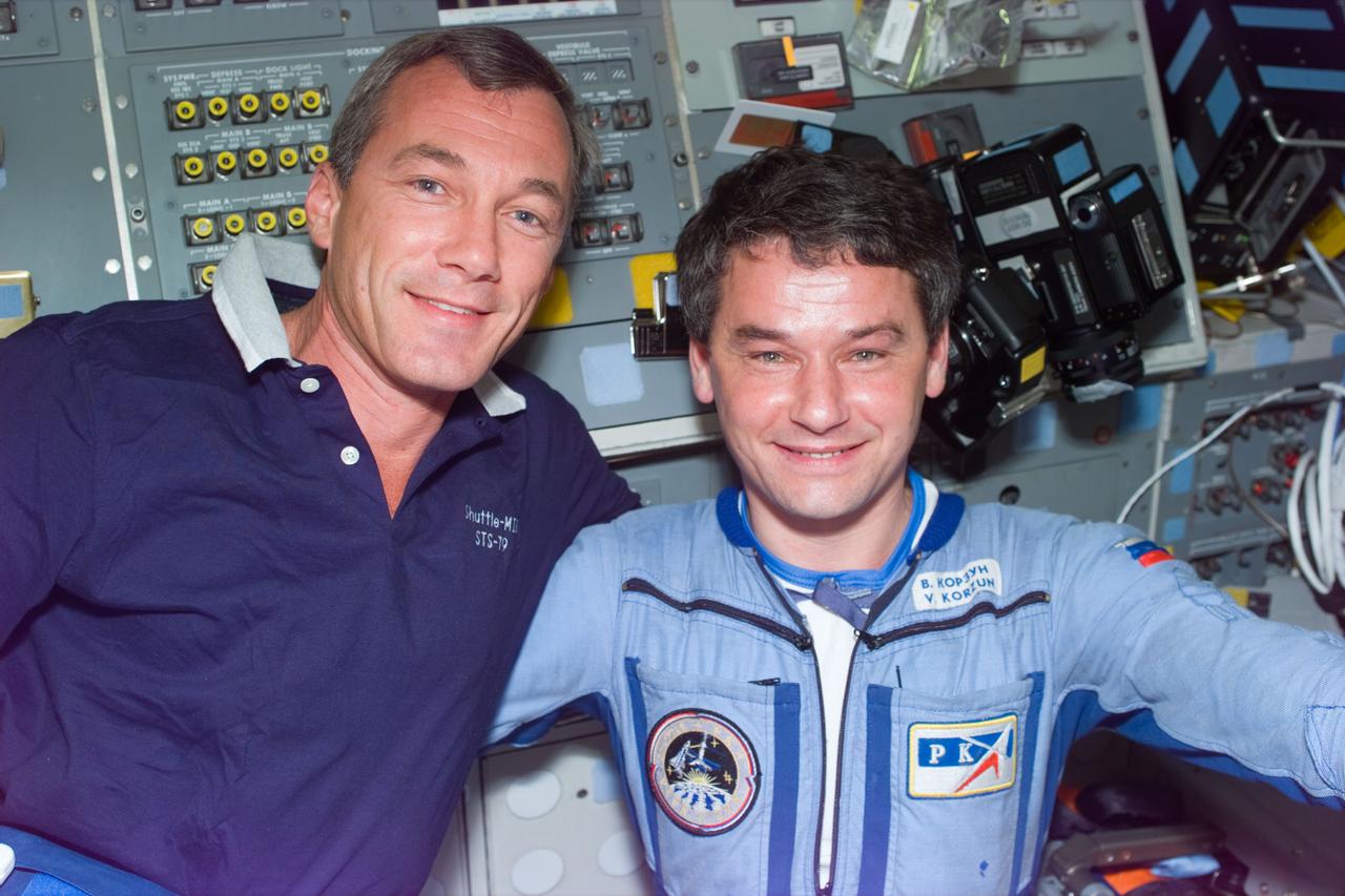 STS79-E-5192 (21 September 1996) --- Astronaut Terrence W. Wilcutt, pilot, talks about shared chores with cosmonaut Valeri G. Korzun, Mir-22 commander on the Space Shuttle Atlantis' flight deck, during Flight Day 6.