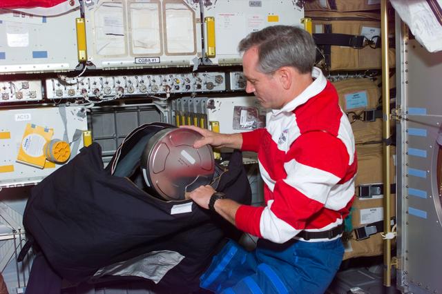 NASA image: Astronaut Akers packs IMAX camera film roll