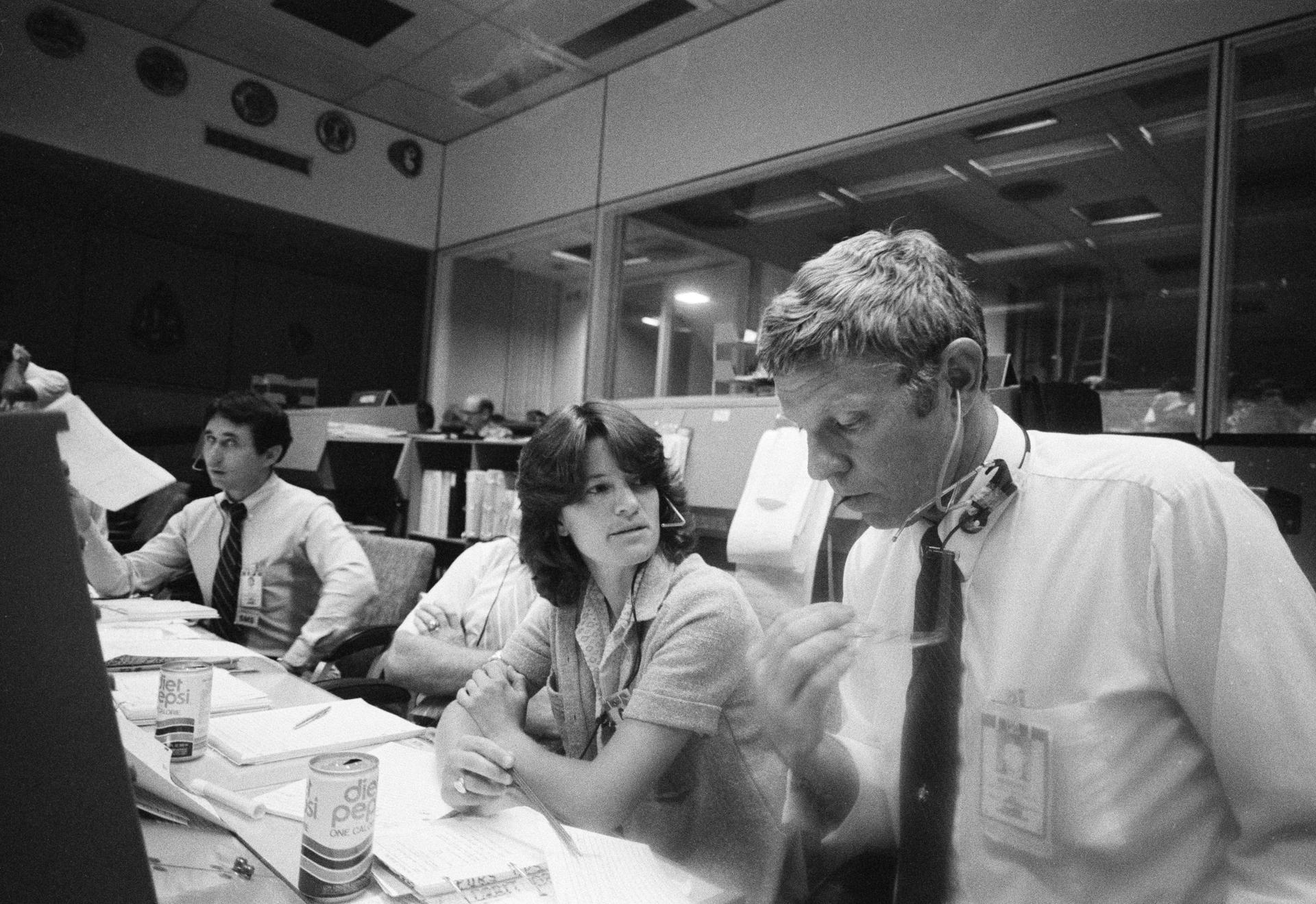 Sally Ride and Dale Moore sit in the mission operations control room at JSC.