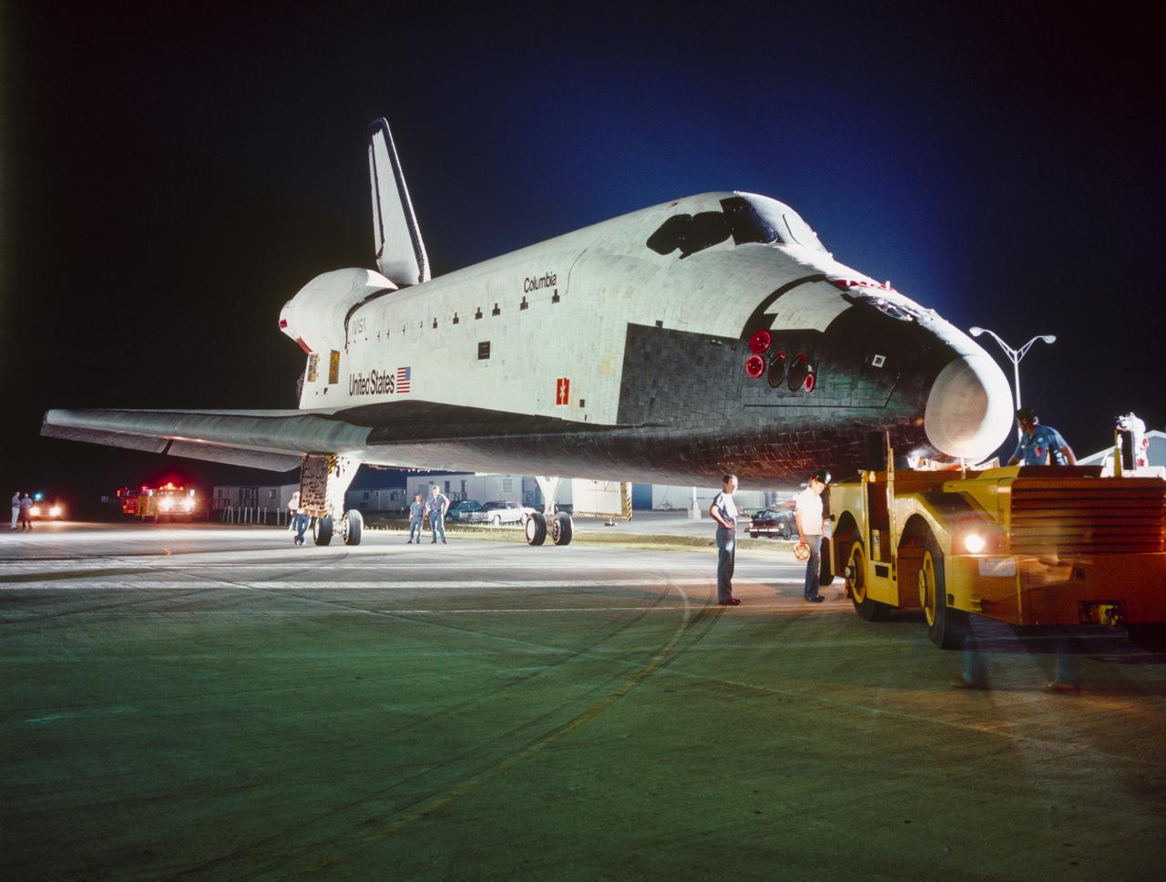 S81-35998 (10 Aug. 1981) --- The orbiter Columbia creeps toward the vehicle assembly building (VAB) during its tow-over from the orbiter processing facility before dawn today. Columbia was backed out of its hangar at 3:54 a.m. and rolled into the cavernous VAB about 25 minutes later. The reusable spacecraft made her maiden flight in April 1981. Photo credit: NASA