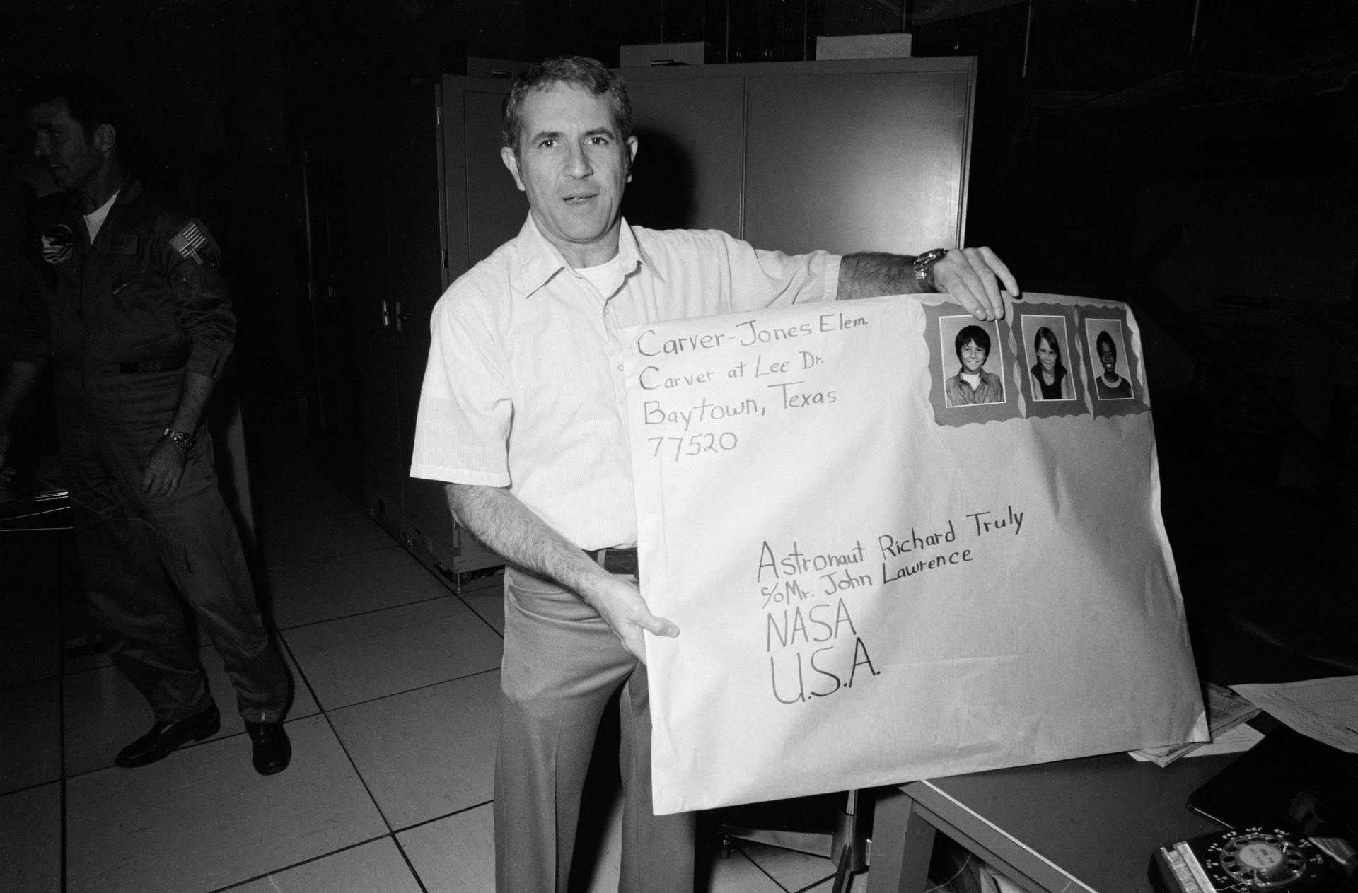 Richard Truly holds a giant envelope addressed to him containing a birthday card from elementary school children.