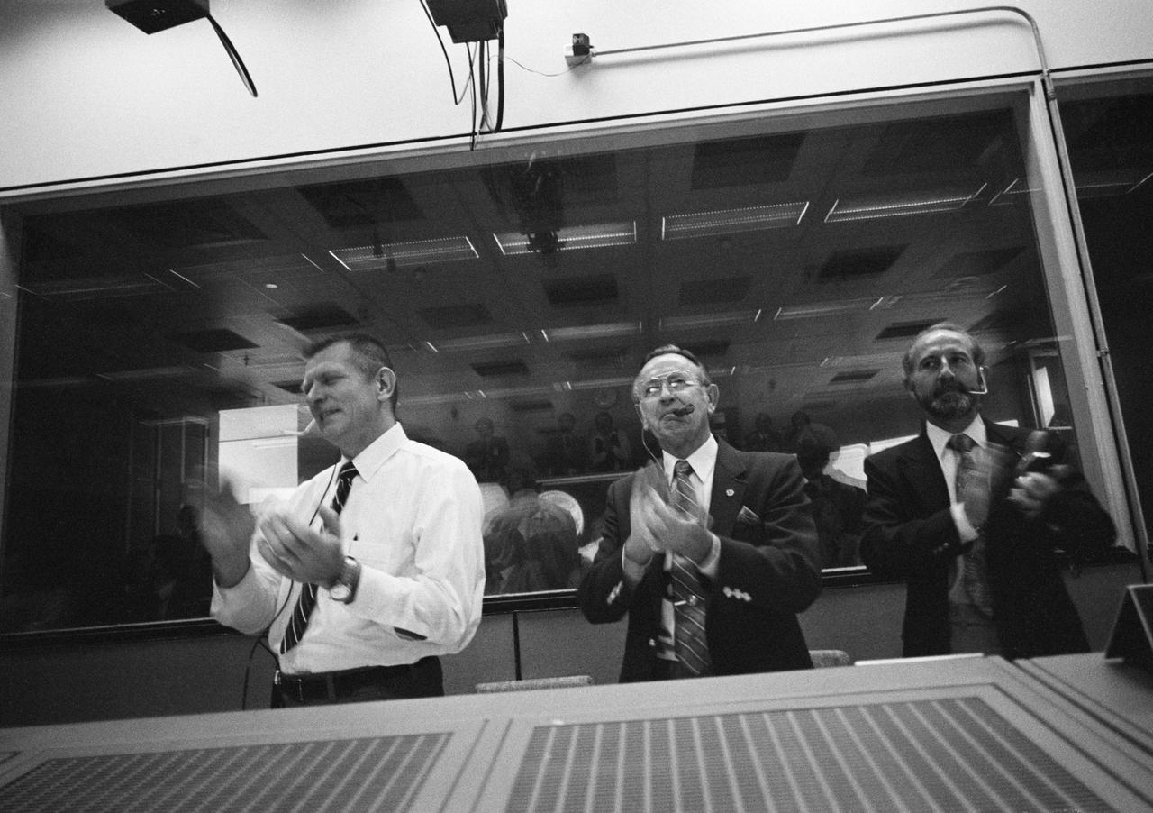 S81-39511 (14 Nov. 1981) --- The successful STS-2 landing at Edwards Air Force Base in California was cause for celebration in the Johnson Space Center?s Mission Control Center shortly before 3:30 p.m. (CST) on Nov. 14, 1981. JSC Director Christopher C. Kraft Jr. (center), not only applauds but enjoys a traditional ?touchdown? cigar, as well.  Eugene F. Kranz (left), deputy director of flight operations at JSC, and Thomas L. Moser of the structures and mechanics division join the celebration. The second flight of the space shuttle Columbia lasted two days, six hours, 13 minutes and a few seconds. Photo credit: NASA
