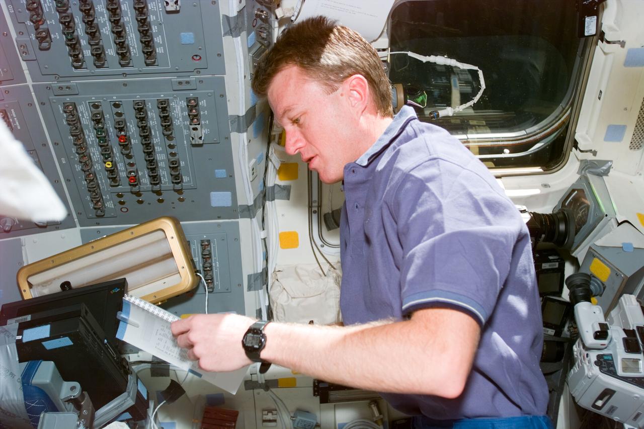 STS081-E-5008 (12 Jan. 1997) --- Astronaut Brent W. Jett, Jr., pilot, looks over a check list on the Space Shuttle Atlantis' aft flight deck as he joins five crew mates (out of frame) in readying the Orbiter for almost ten days in Earth-orbit.  Part of that time, Atlantis will be docked with Russia's Mir Space Station.  The second exchange of NASA astronauts serving as cosmonaut guest researchers will occur at that time.  The scene was recorded with an Electronic Still Camera (ESC) and later downlinked to flight controllers in Houston, Texas.
