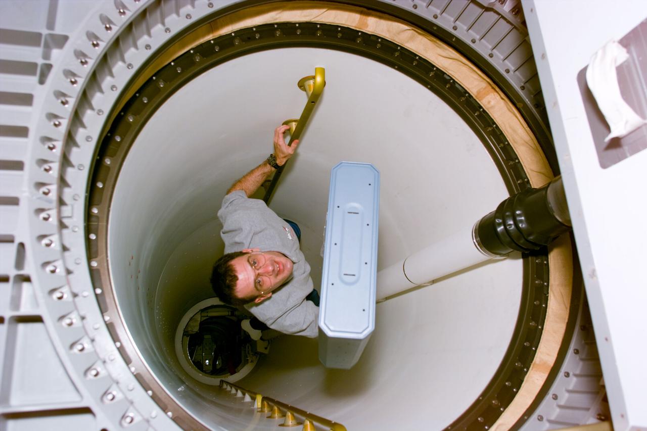 STS081-E-05100 (12 Jan. 1997) --- Astronaut Peter J. K. (Jeff) Wisoff, mission specialist, carries a stowage drawer from the middeck of the Space Shuttle Atlantis' crew cabin through a connective tunnel into the Spacehab Double Module (DM). In a few days, Wisoff and his five crew mates are scheduled to dock with Russia's Mir Space Station and pick up John E. Blaha, NASA astronaut who has been serving as a cosmonaut guest researcher since September, 1996. Astronaut Jerry M. Linenger will replace Blaha onboard Mir and the transfer will mark the second such direct exchange of cosmonaut guest researchers, though Linenger will be the fourth United States astronaut to spend a lengthy stay on Mir.