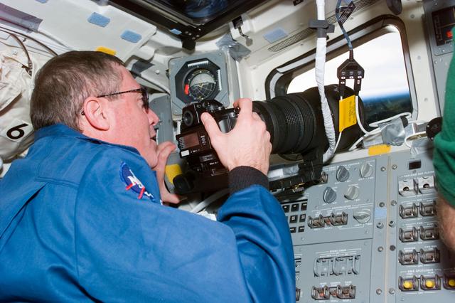 NASA image: STS-81 commander Baker at aft flight deck window with camera