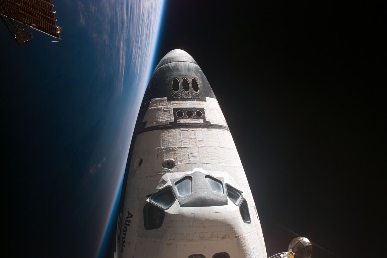 STS081-E-05436 (15 Jan. 1997) --- Soon after the astronauts docked the space shuttle Atlantis with Russia's Mir Space Station, astronaut Marsha S. Ivins, STS-81 mission specialist, went aboard the Mir complex and sought a window through which she could record this image of Atlantis' forward section. A solar array panel on the Mir is seen in one corner and the Ku-band antenna for Atlantis is visible in another. This view was taken with an electronic still camera (ESC). Photo credit: NASA