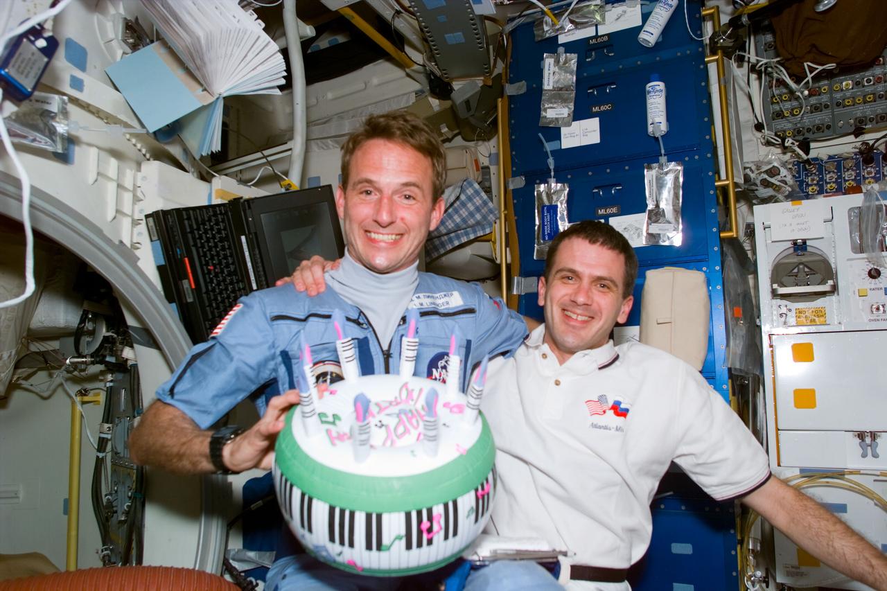 STS081-E-05498 (16 Jan. 1997) --- Supplies and equipment transfer are the topic of the day, as the Space Shuttle Atlantis and Russia's Mir Space Station respective commanders have a discussion aboard the Orbiter. Left to right are cosmonauts Valeri G. Korzun and Aleksandr Y. Kaleri, Mir-22 commander and flight engineer respectively; along with astronaut Michael A. Baker, mission commander. The photograph was recorded with an Electronic Still Camera (ESC) and later was downlinked to flight controllers in Houston, Texas.