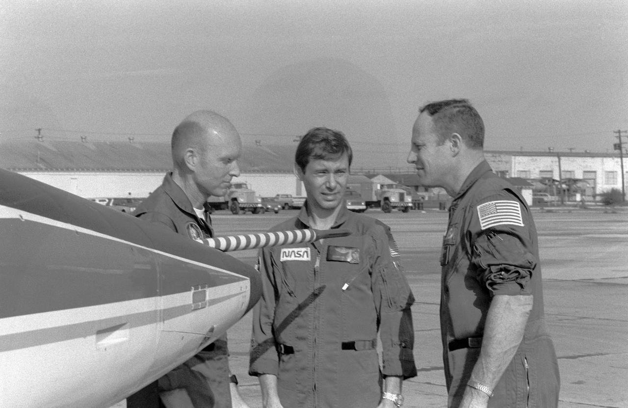 S82-28704 (20 March 1982) --- Astronaut Jack R. Lousma, STS-3 commander, seems to be saying, "?see you guys down there," prior to boarding a T-38 jet trainer and heading for KSC in Florida. Astronaut C. Gordon Fullerton, left, STS-3 pilot, will man the front seat of another T-38, with astronaut Brewster H. Shaw, center, as rear sat passenger. The STS-3 crew has just bade farewell to news media representatives and members of the general public on hand for the departure. Photo credit: NASA