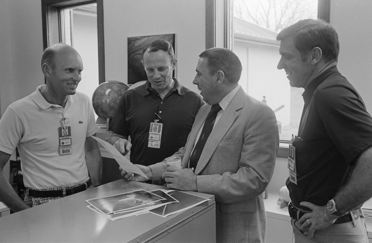 S82-28950 (1 April 1982) --- During a break from a debriefing session, the STS-3 crew members look over some of the photography of their launch from the Kennedy Space Center along with other participants of the meeting. Astronaut Jack R. Lousma is second from left; astronaut C. Gordon Fullerton is at left. They are commander and pilot, respectively, of STS-3. George W. S. Abbey, director of flight operations at JSC, is second from right, and astronaut Joe H. Engle, STS-2 commander, is at right. Photo credit: NASA