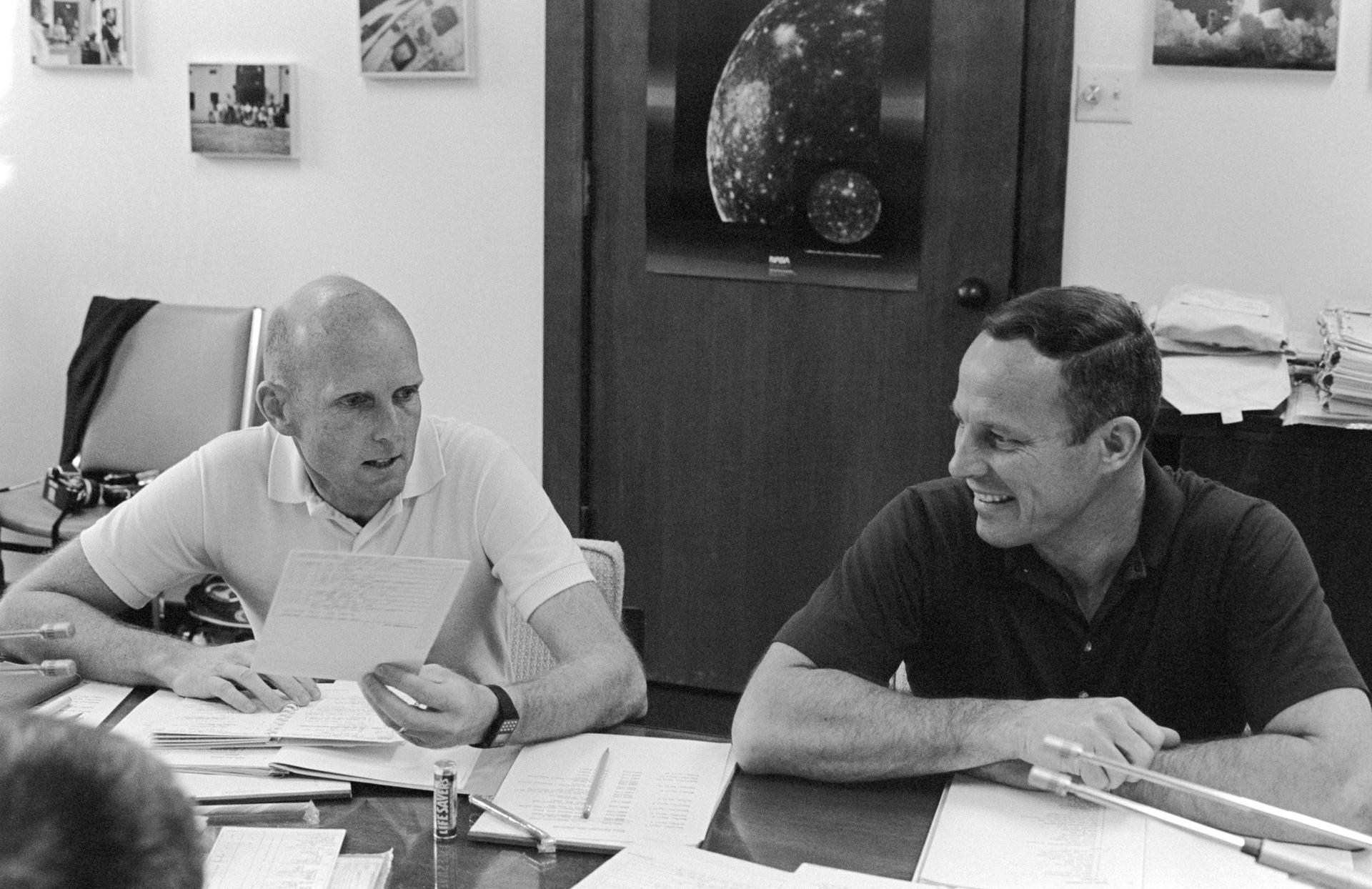 Gordon Fullerton and Jack Lousma sit at a table during an STS-3 debriefing
