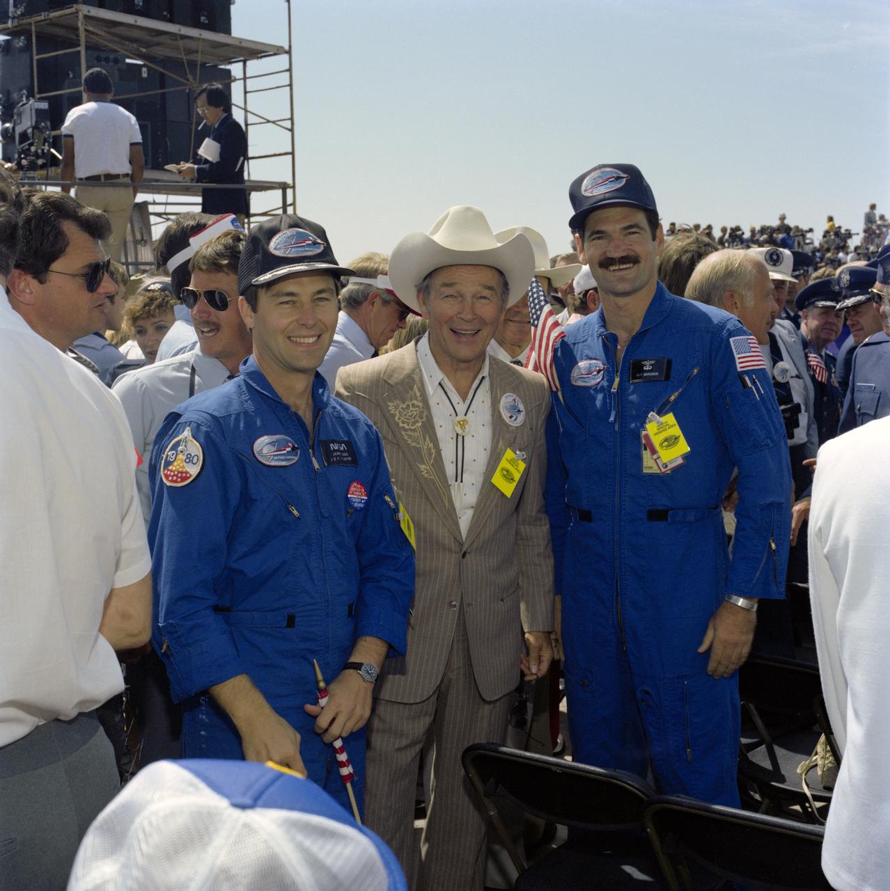 S82-33226 (4 July 1982) --- Inveterate space fan Roy Rogers with astronauts Jerry L. Ross, left, and Guy S. Gardner at Edwards Air Force Base for the landing of the space shuttle Columbia at the conclusion of the STS-4 mission on July 4, 1982. Ross and Gardner piloted chase planes involved in the approach and landing operations for the flight?s conclusion. Also present at the landing was (near far right) former astronaut Edwin E. Aldrin Jr., lunar module pilot for the historic first moon landing of almost 13 years ago. Photo credit: NASA