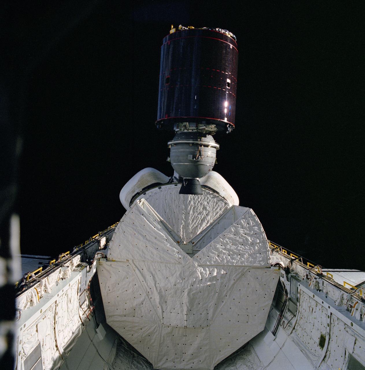 S82-39793 (11 Nov. 1982) --- The Satellite Business Systems (SBS-3) spacecraft springs from its protective ?cradle? in the cargo bay of the Earth-orbiting space shuttle Columbia and head toward a series of maneuvers that will eventually place it in a geosynchronous orbit. This moment marks a milestone for the Space Transportation System (STS) program, as the placement of the communications satellites represents the first deployment of a commercial satellite from an orbiting space vehicle. Part of Columbia?s wings can be seen on both the port and starboard sides. Also both orbital maneuvering system (OMS) pods are seen at center. The vertical stabilizer is obscured by the satellite. The closed protective cradle device shielding Telesat Canada?s ANIK C-3 spacecraft is seen between the other shield and the OMS pod. ANIK is to be launched on the mission?s second day. This photograph was exposed through the aft windows of the flight deck. Photo credit: NASA