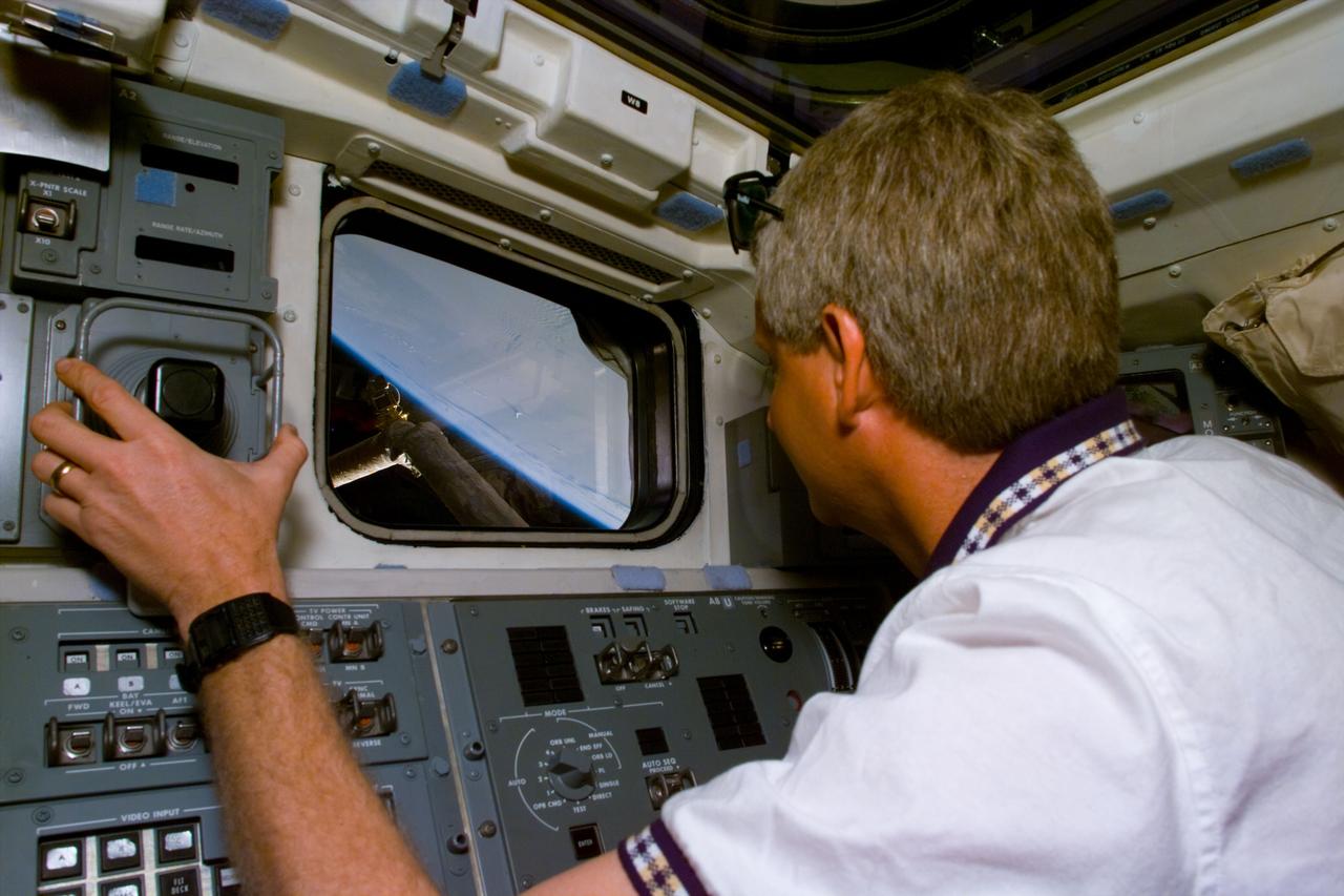 S82-E-5016 (12 Feb. 1997) --- Astronaut Steven A. Hawley, STS-82 mission specialist, controls Discovery's Remote Manipulation System (RMS), from the aft flight deck. Hawley and his crew mates are preparing for a scheduled Extravehicular Activity (EVA) with the Hubble Space Telescope (HST), which will be pulled into the Space Shuttle Discovery's cargo bay with the aid of the Remote Manipulator System (RMS). A series of EVA's will be required to properly service the giant telescope. Hawley served as a mission specialist on NASA's 1990 mission which was responsible for placing HST in Earth-orbit. This view was taken with an Electronic Still Camera (ESC).