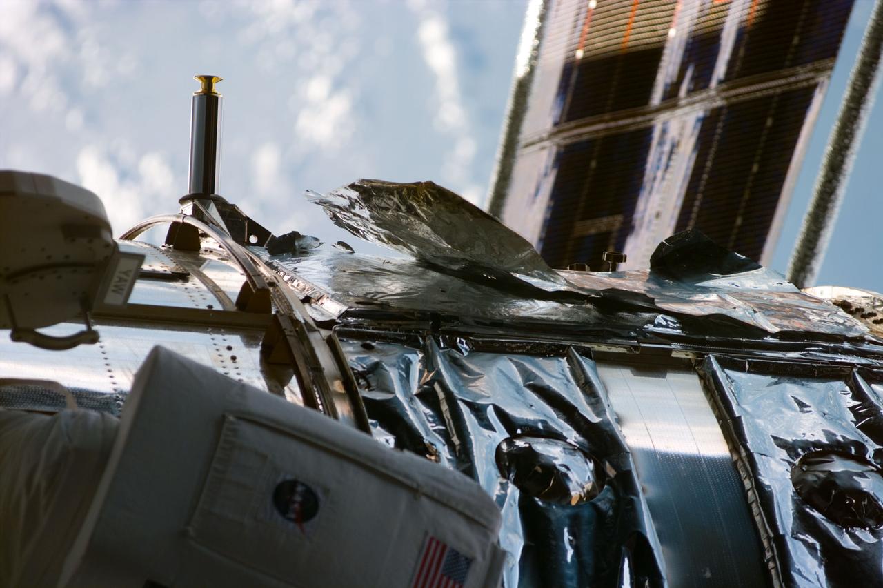 S82-E-5369 (15 Feb. 1997) --- This photograph, taken from onboard the Space Shuttle Discovery with an Electronic Still Camera (ESC) shows a tear in the thermal insulation of the Hubble Space Telescope (HST) Bay #8.