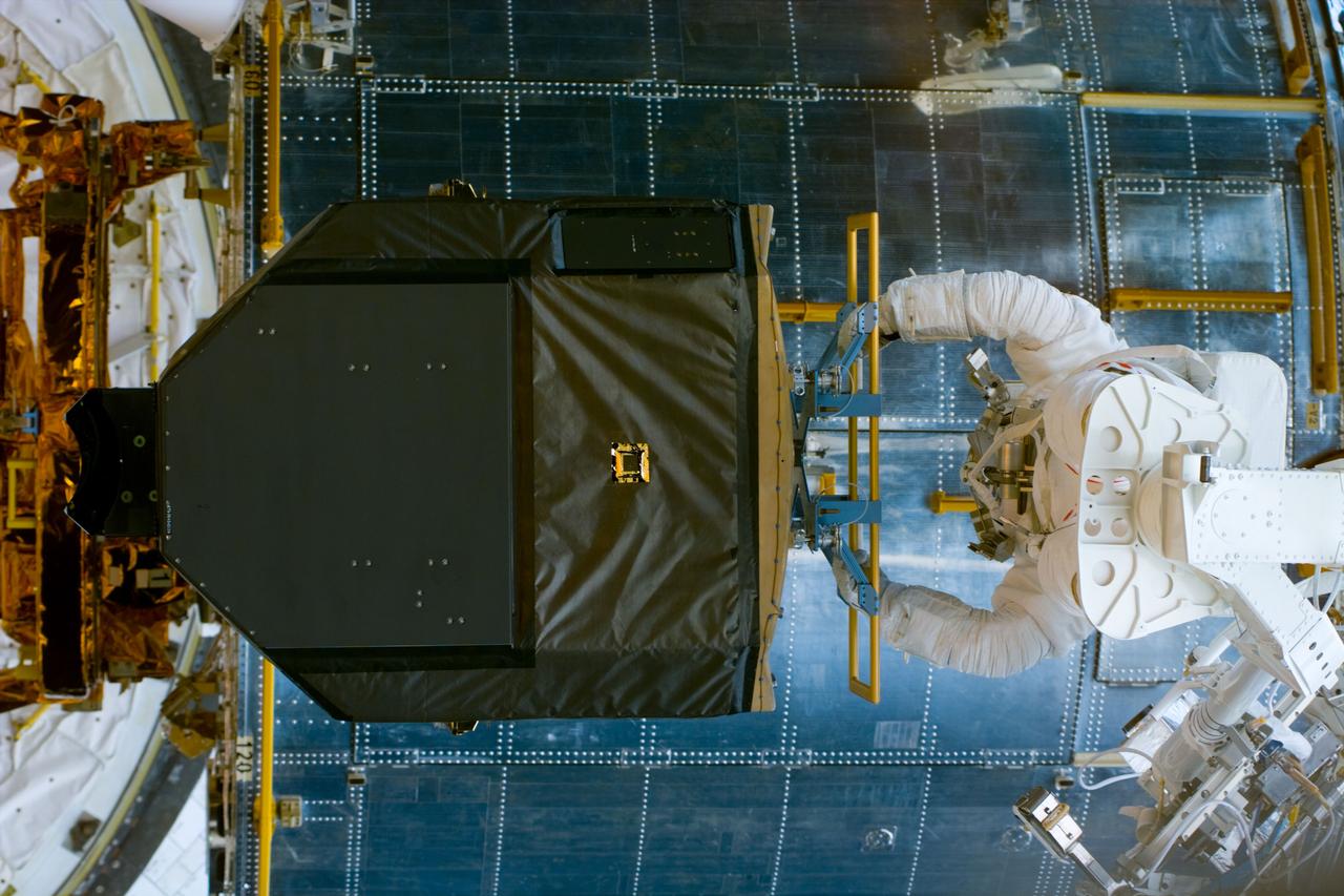 S82-E-5404 (15 Feb. 1997) --- Astronaut Gregory J. Harbaugh on the Remote Manipulator System (RMS) with the Fine Guidance Sensor (FGS), during the repair of the Hubble Space Telescope (HST).  This view was taken with an Electronic Still Camera (ESC).