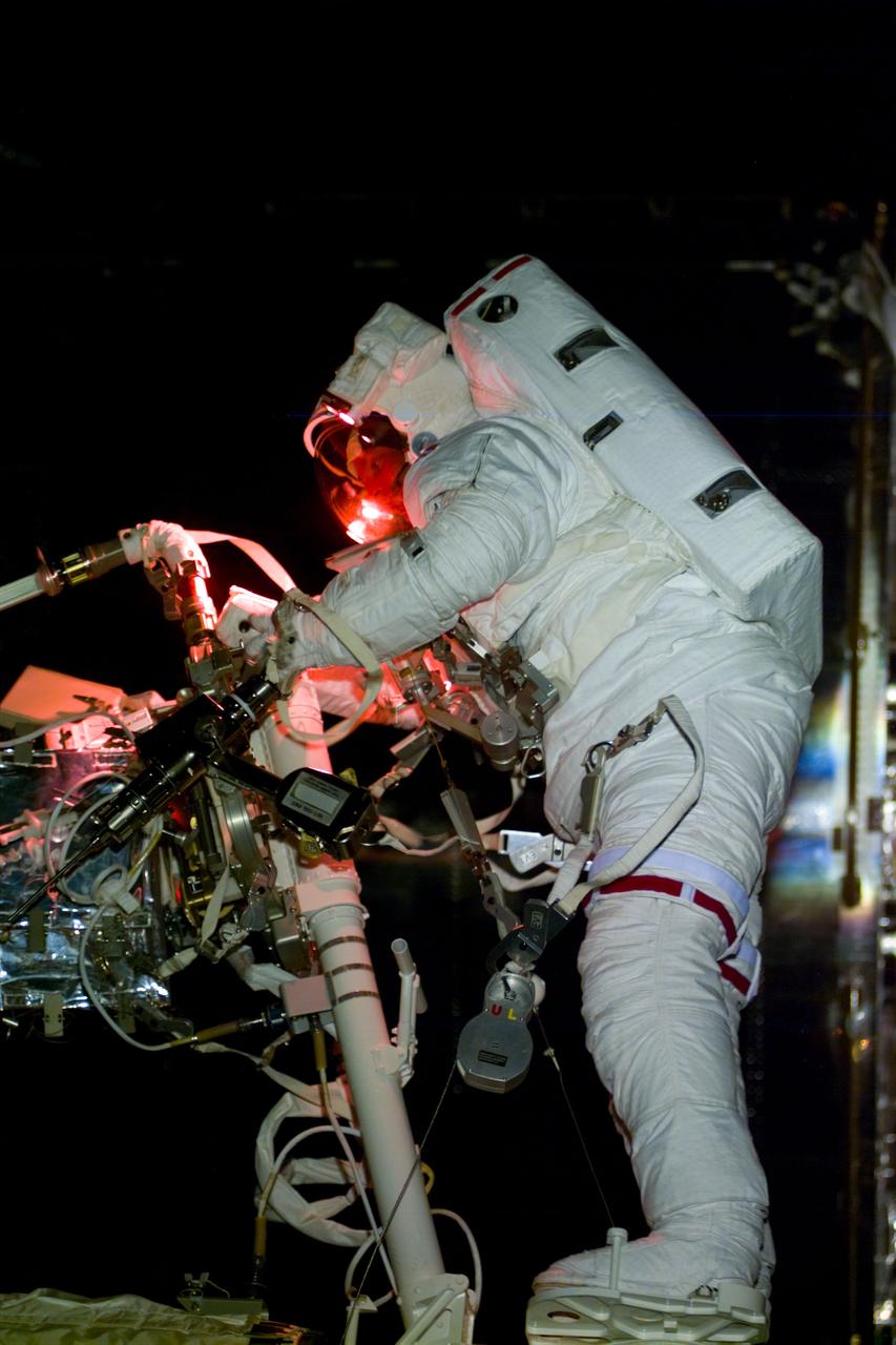 S82-E-5606 (17 Feb. 1997) --- Astronaut Gregory J. Harbaugh at work on Hubble Space Telescope (HST), with the assistance of astronaut Joseph R. Tanner (out of frame) on Remote Manipulator System (RMS).  After replacing the HST's Solar Array Drive Electronics (SADE), Harbaugh and Tanner replaced the Magnetic Sensing System (MSS) protective lids with new, permanent covers; and they installed pre-cut insulation pieces to correct tears in the HST's protective covering caused by temperature changes in space. This view was taken with an Electronic Still Camera (ESC).