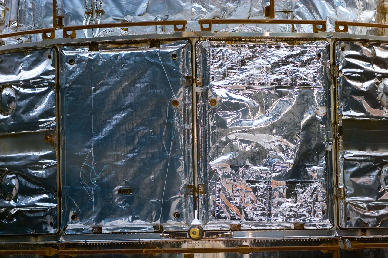 S82-E-5891 (11-21 Feb. 1997) --- Several patchwork pieces on bay doors accomplished on fifth Extravehicular Activity (EVA). This view was taken with an Electronic Still Camera (ESC).