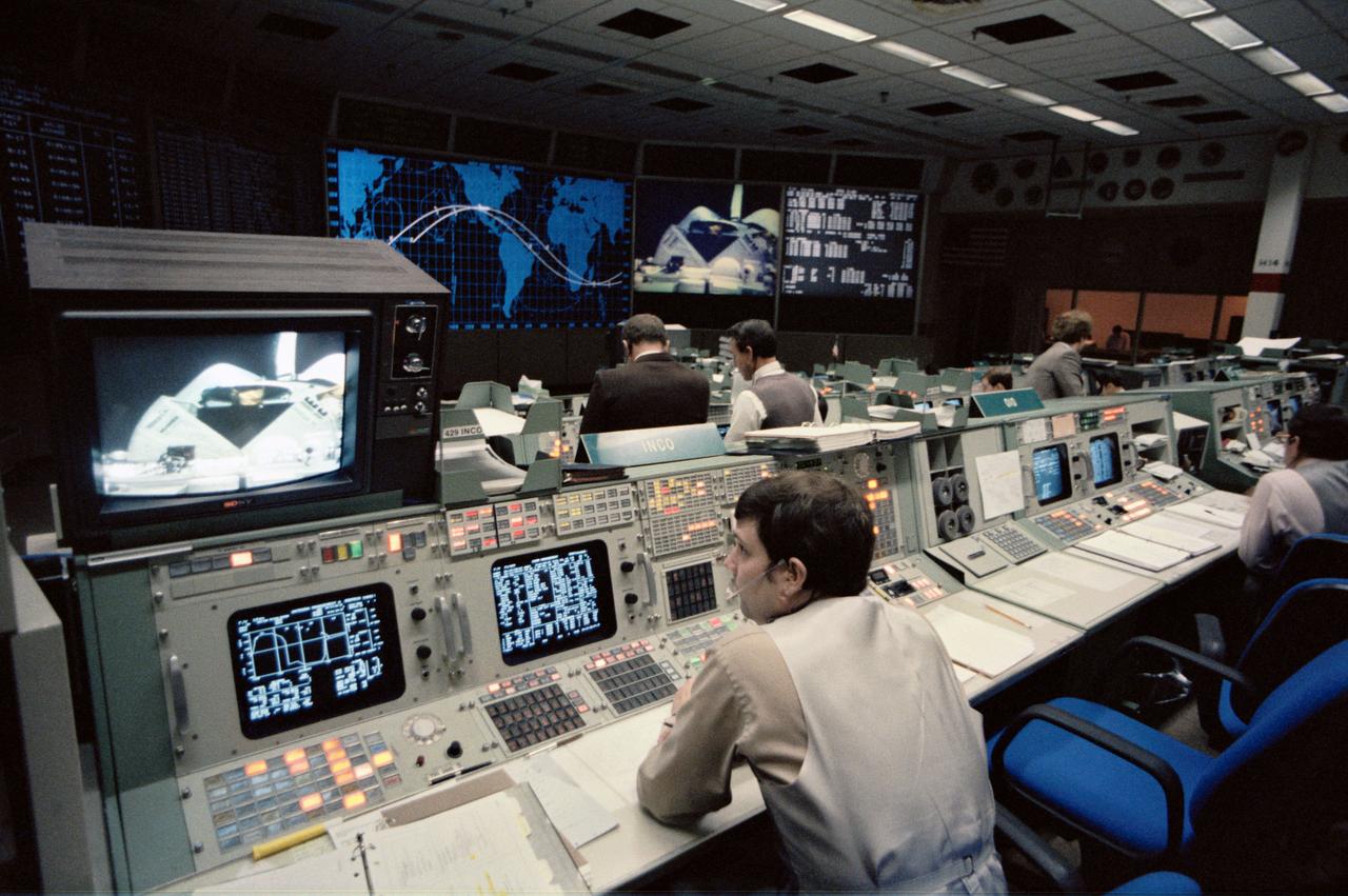 S84-26332 (3 Feb 1984) --- Robert E. Castle, integrated communications officer (INCO), plays an important role in the first television transmission from the Earth-orbiting Space Shuttle Challenger. Castle, at a console in the Johnson Space Center?s mission operations control room (MOCR) in the mission control center, is responsible for ground controlled television from the orbiter on his shift. Here, the Westar VI satellite is seen in the cargo bay just after opening of the payload bay doors.