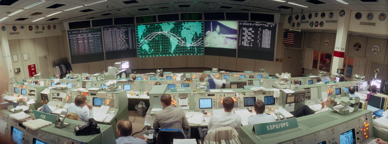 S84-26985 (7 Feb 1984) --- Flight controllers in the mission operations control room (MOCR) of the Johnson Space Center?s mission control center monitor the extravehicular activity (EVA) of Astronauts Bruce McCandless II and Robert L. Stewart. The photograph was taken with a wide angle lens on a 35mm camera deployed in the aft center point of the MOCR.